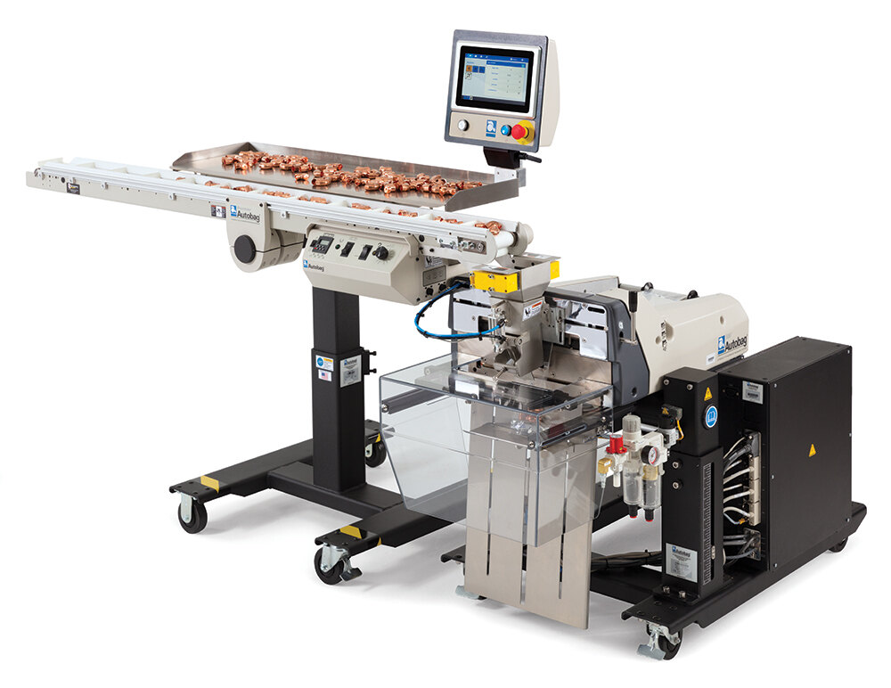 Autobag Maximizer flighted conveyor with copper fittings, mounted over a bagger