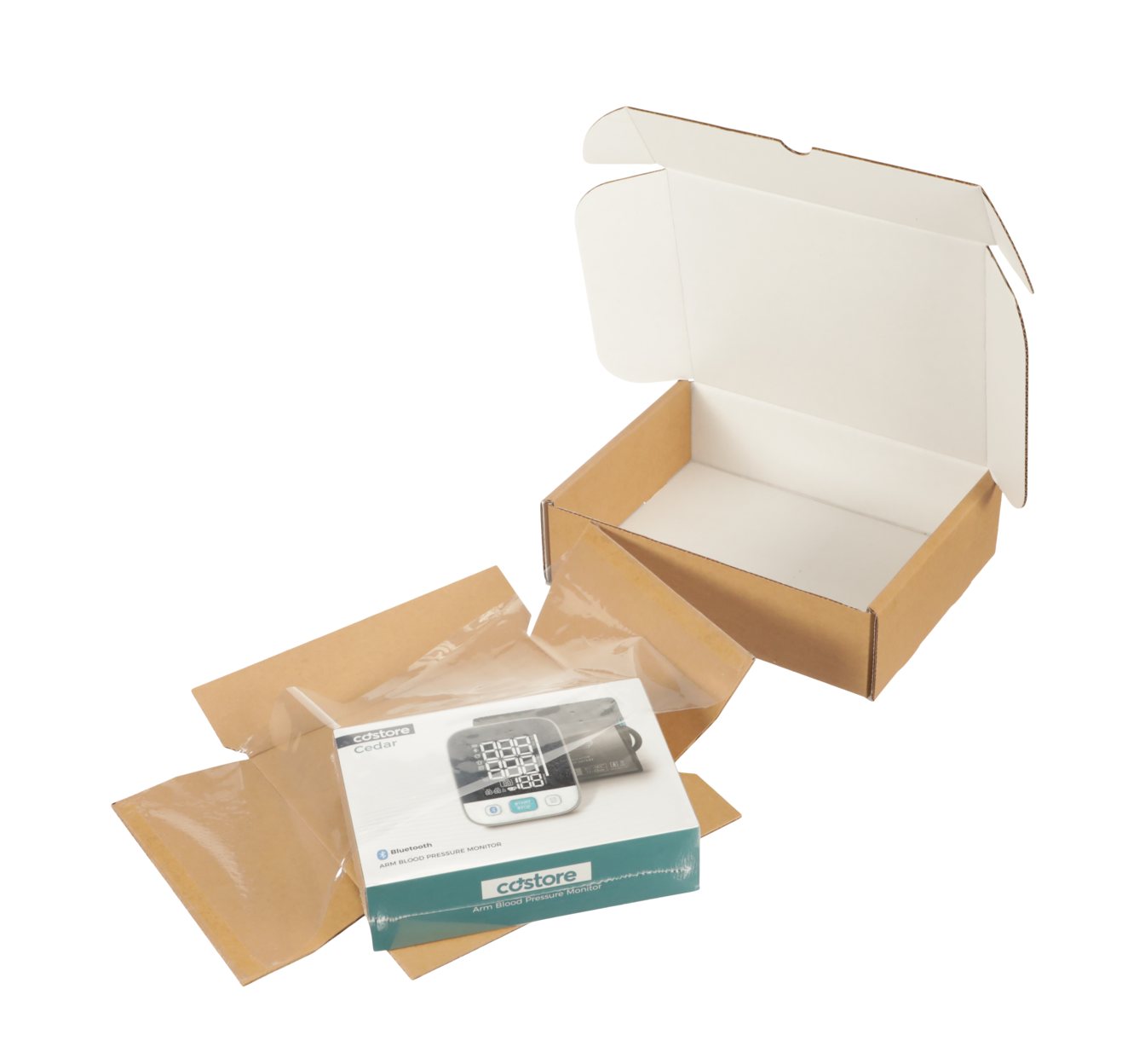 A boxed blood pressure monitor on its Korrvu retention pack, beside the open white carton it ships in