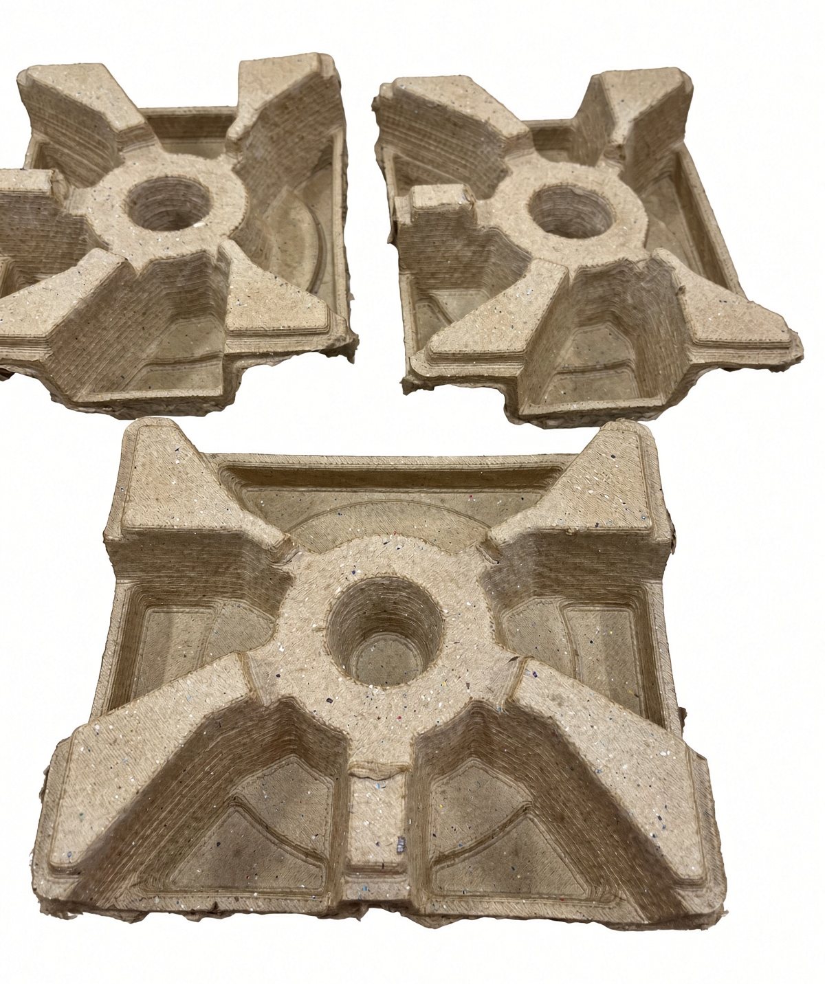 Three molded pulp trays shaped for a brake rotor, before the part goes in