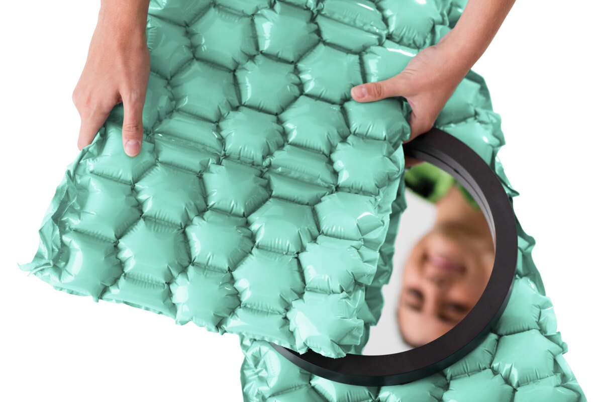 Hands wrapping a round mirror in green AirPouch FastWrap High Loft honeycomb bubble
